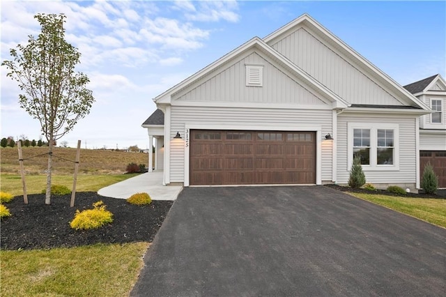 view of front facade with board and batten siding, driveway, and an attached garage