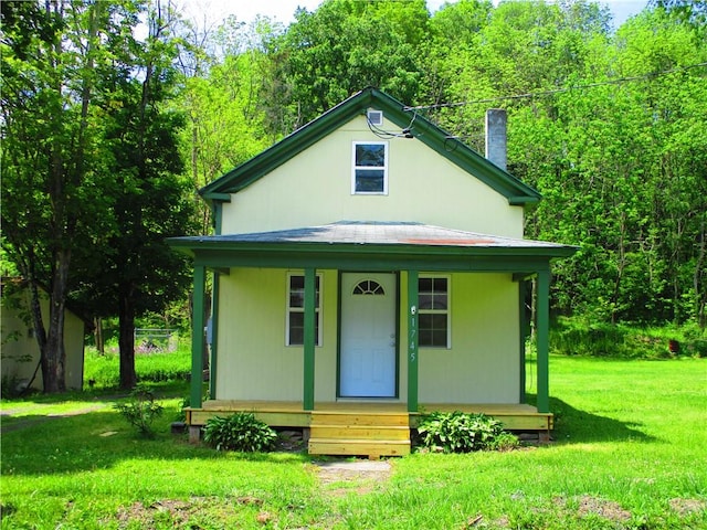 view of front of property featuring entry steps, a chimney, and a front lawn