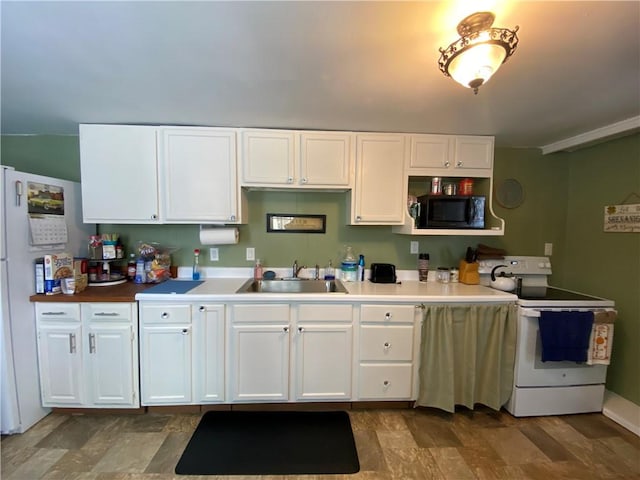 kitchen with black microwave, a sink, baseboards, white cabinets, and electric stove