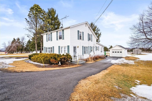 view of front of home featuring a garage, driveway, and an outdoor structure