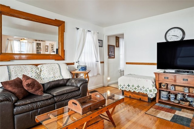 living area featuring baseboards and hardwood / wood-style flooring