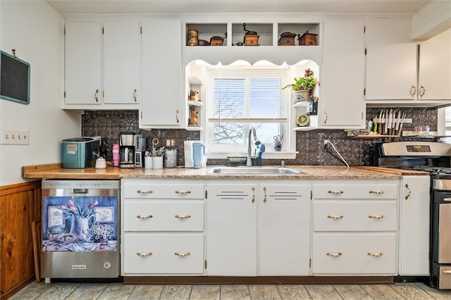 kitchen featuring white cabinets, decorative backsplash, stainless steel appliances, light countertops, and a sink