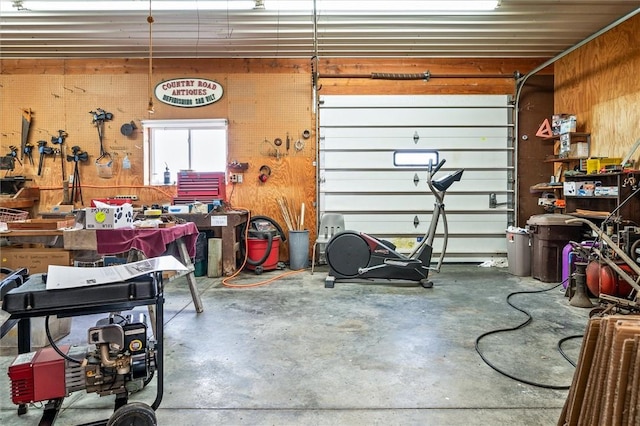 garage featuring wooden walls and a workshop area