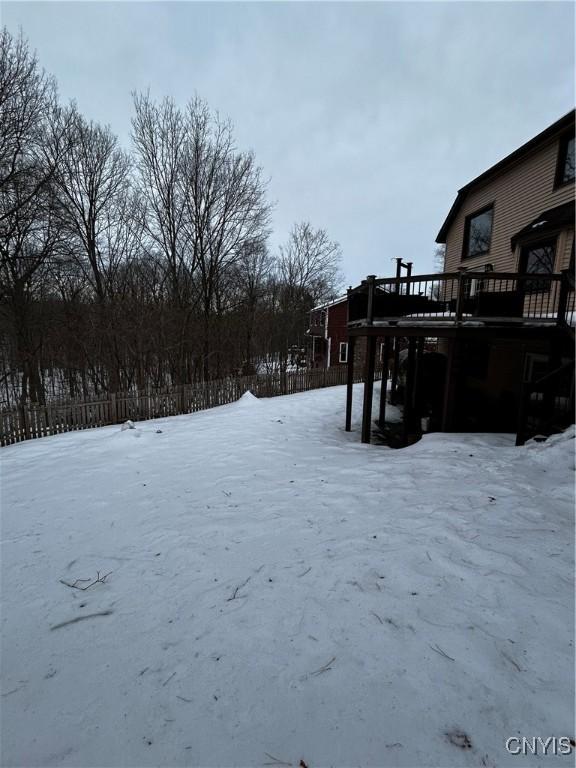 yard covered in snow featuring a deck