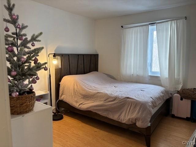 bedroom with radiator and light wood-style flooring