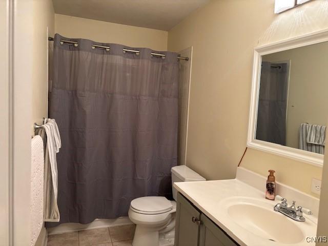 full bathroom featuring vanity, tile patterned flooring, toilet, and a shower with curtain