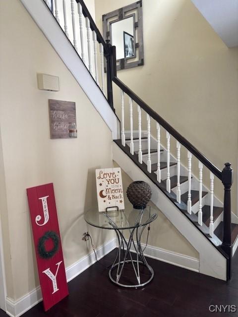 staircase featuring baseboards and wood finished floors