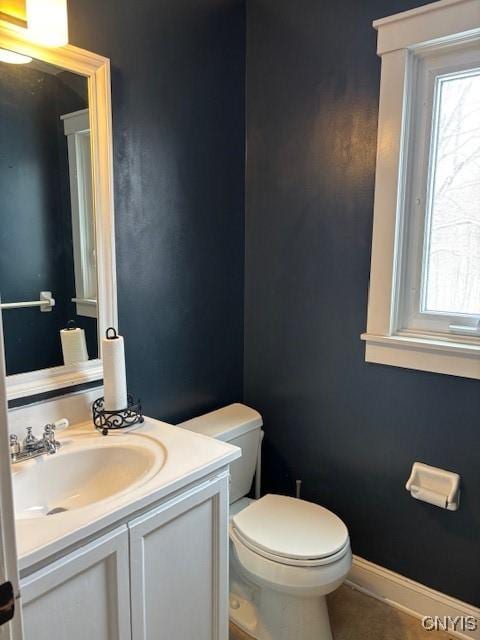 bathroom featuring tile patterned flooring, vanity, toilet, and baseboards