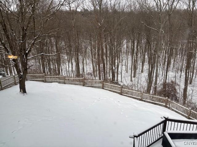 yard layered in snow with fence