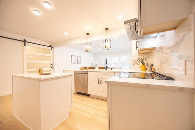 kitchen with a barn door, decorative light fixtures, a peninsula, white cabinetry, and stainless steel dishwasher