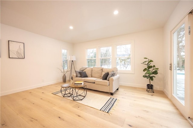 living room featuring plenty of natural light, light wood-style flooring, baseboards, and recessed lighting