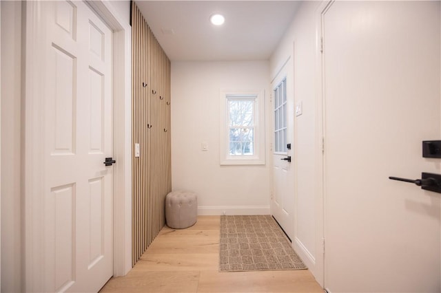 doorway to outside featuring light wood-type flooring and baseboards