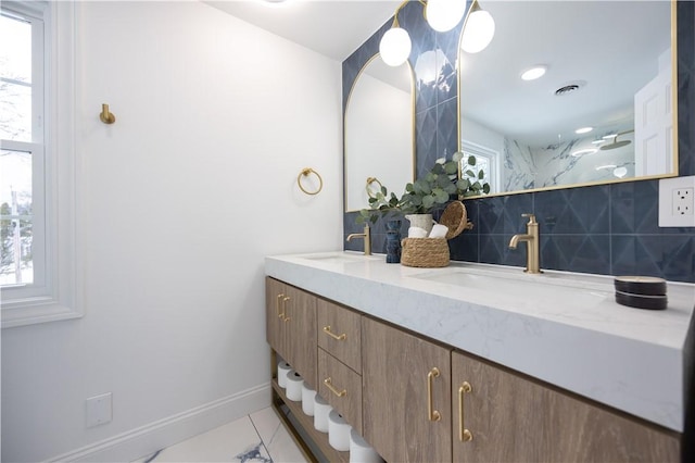 bathroom with a wealth of natural light, visible vents, a sink, and decorative backsplash