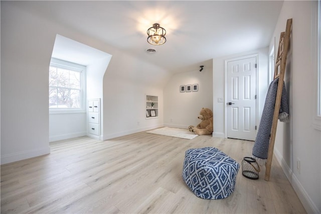 interior space with lofted ceiling, light wood-style flooring, and baseboards