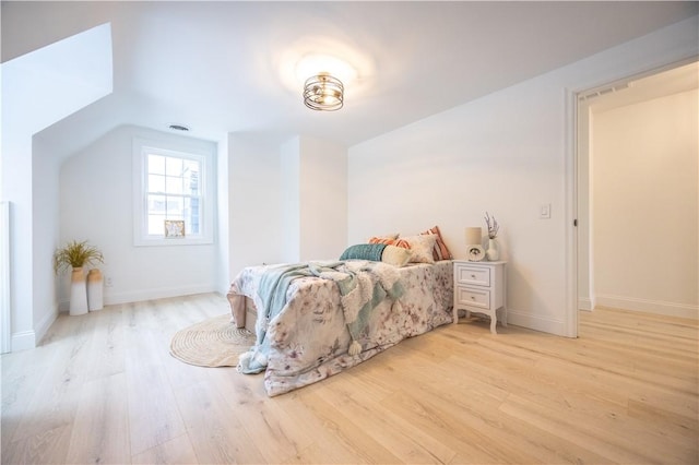 bedroom with light wood-type flooring, visible vents, and baseboards