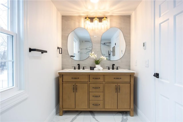 bathroom with a wealth of natural light, marble finish floor, and a sink