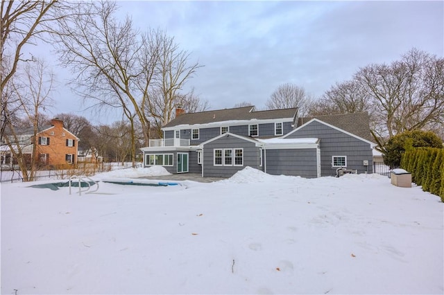 snow covered property with a chimney