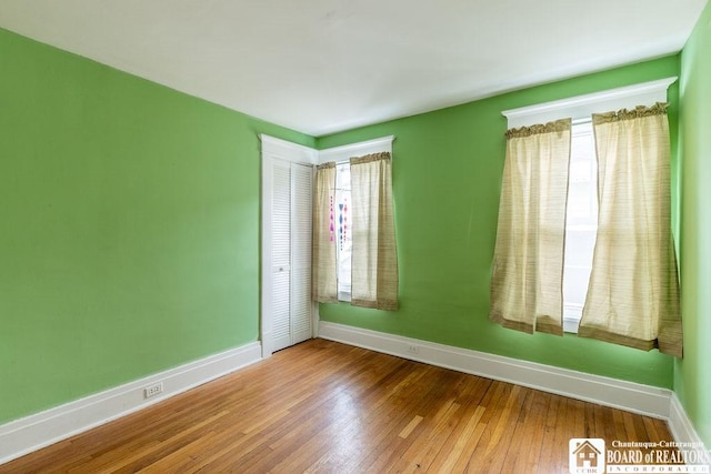 empty room featuring wood finished floors and baseboards