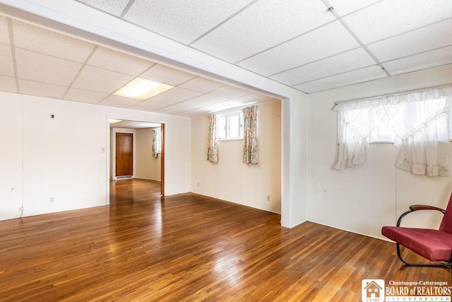 unfurnished room with a paneled ceiling and wood-type flooring