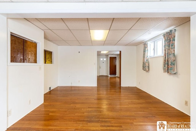 unfurnished room featuring a drop ceiling and wood finished floors