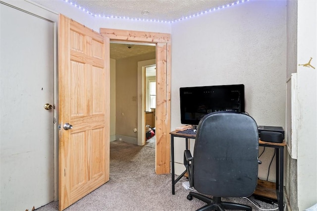 office space featuring light carpet and a textured ceiling