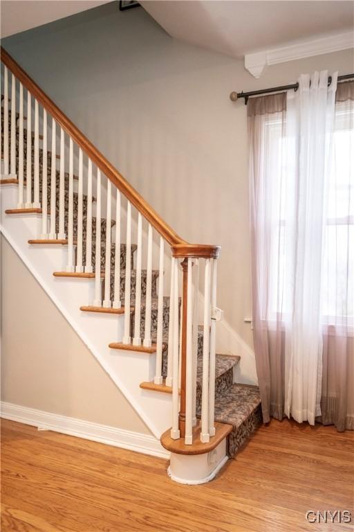 stairs with wood finished floors and baseboards