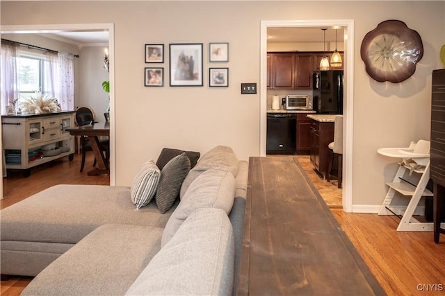 living room with a toaster, baseboards, and wood finished floors