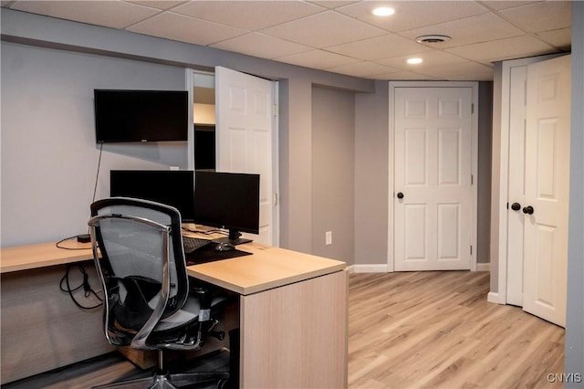 office space featuring light wood-style floors, recessed lighting, a drop ceiling, and baseboards