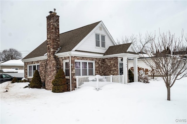 view of front of property with roof with shingles and a chimney