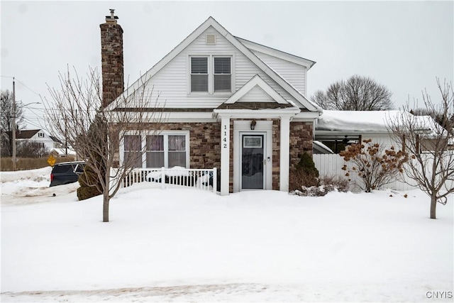 view of front of property featuring stone siding and a chimney