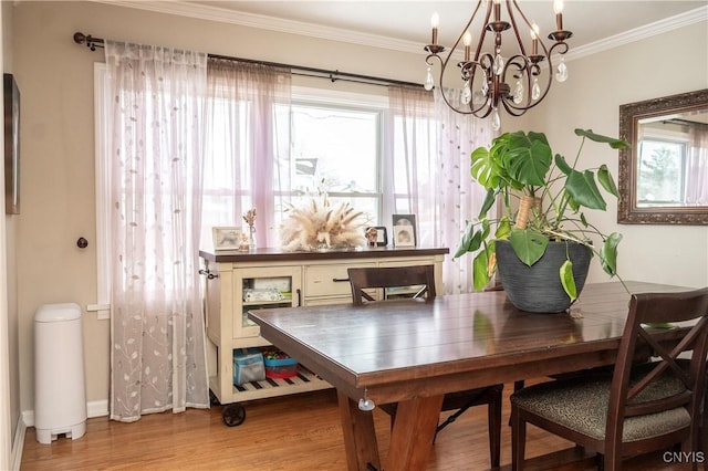 dining area with a notable chandelier, baseboards, wood finished floors, and crown molding