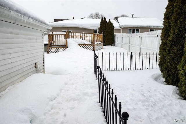 yard covered in snow featuring fence private yard and a deck