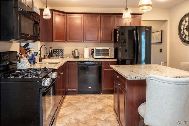 kitchen with a toaster, decorative light fixtures, black appliances, a kitchen bar, and a sink