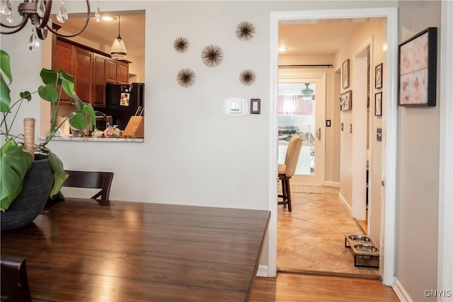 corridor with light wood-style flooring and baseboards