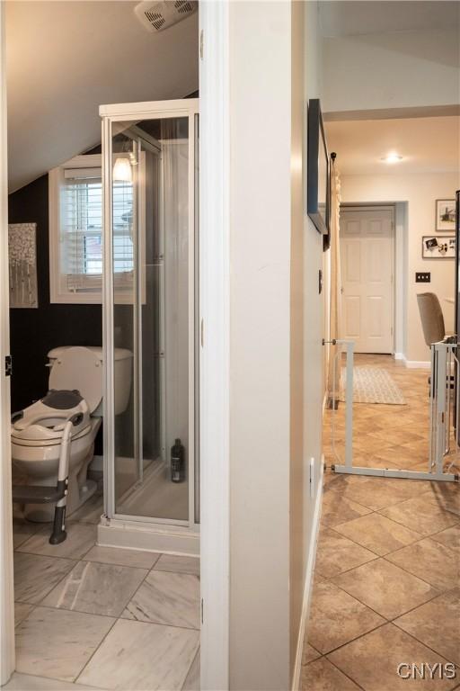 bathroom with lofted ceiling, toilet, visible vents, and baseboards