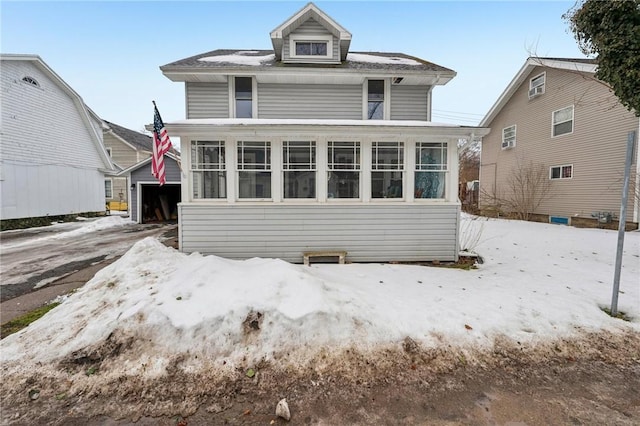 view of front of house with a detached garage and an outbuilding