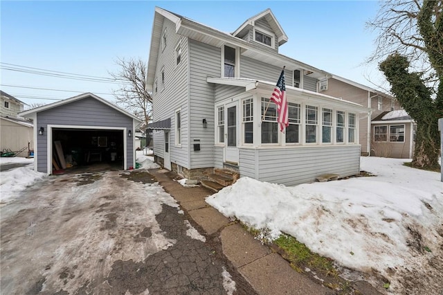 traditional style home featuring entry steps, a detached garage, and an outbuilding