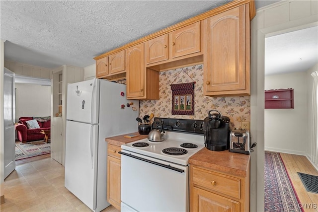 kitchen with white appliances, light countertops, a textured ceiling, and light brown cabinetry