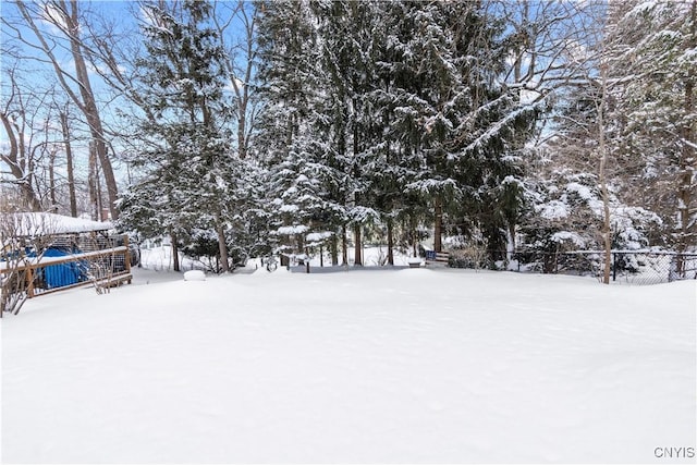 snowy yard featuring fence