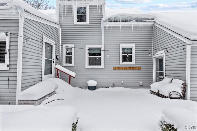 view of snow covered back of property