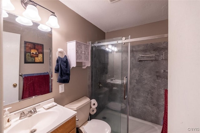 full bath with a textured ceiling, vanity, a shower stall, and toilet