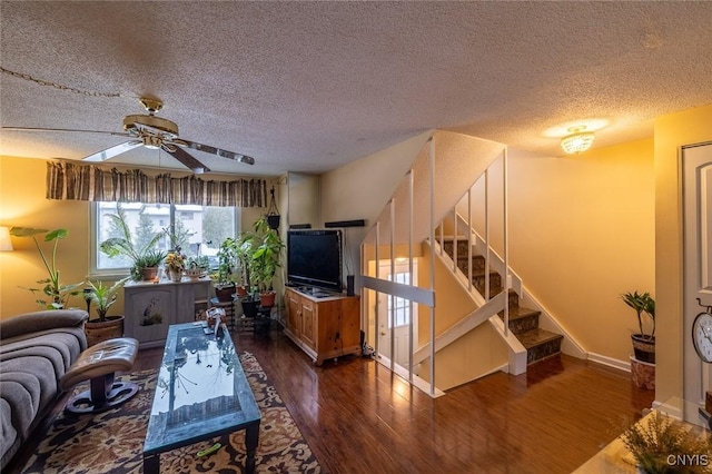 living room featuring stairs, ceiling fan, dark wood-style flooring, and a textured ceiling