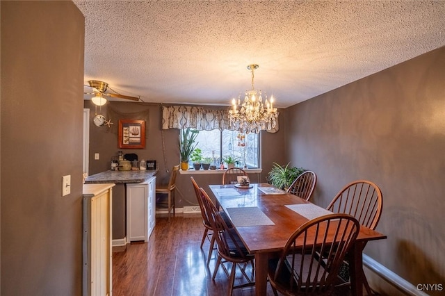 dining area featuring a textured ceiling, ceiling fan with notable chandelier, dark wood finished floors, and baseboards