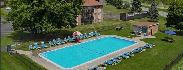 community pool with a lawn and fence