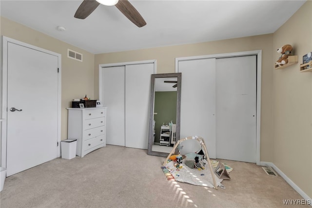 rec room with a ceiling fan, visible vents, and light carpet