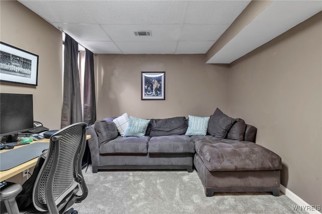 interior space with baseboards, a drop ceiling, visible vents, and light colored carpet