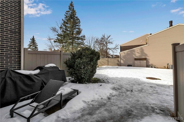 yard layered in snow featuring a fenced backyard