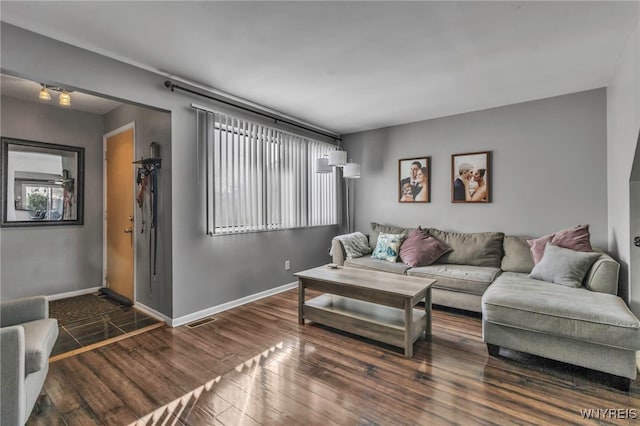 living area featuring baseboards and dark wood-style flooring