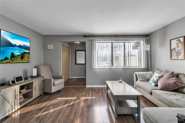 living room with dark wood-type flooring and baseboards