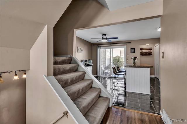 stairs featuring ceiling fan, wood finished floors, and baseboards